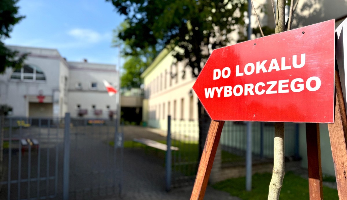 czerwona tabliczka z napisem do lokalu wyborczego